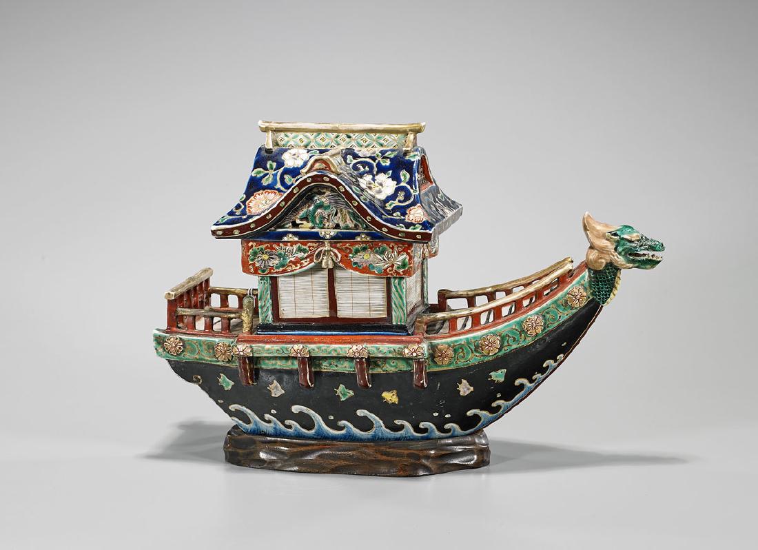 Antique Japanese Kutani Porcelain Sectional Boat: Antique Japanese Kutani porcelain sectional boat; featuring a dragon-form figurehead to bow; the body showing fish amid stylized waves on a black ground; surmounted by a floral-decorated roof and hous