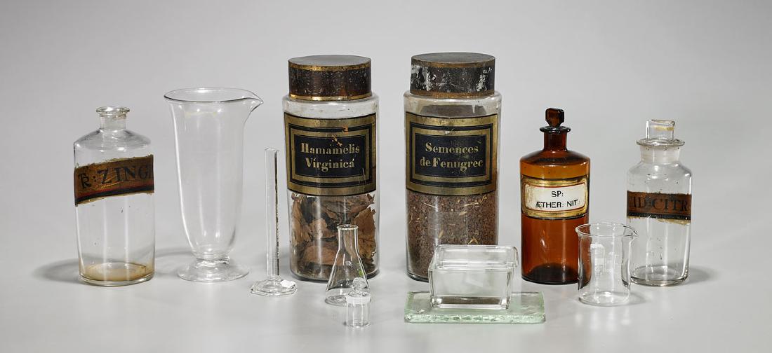 Group of Various Medical Beakers & Containers: Group of 15 various glass and porcelain medical beakers and containers; some with labels; together with pill cutting plate; H: 10" (tallest, approx.)
