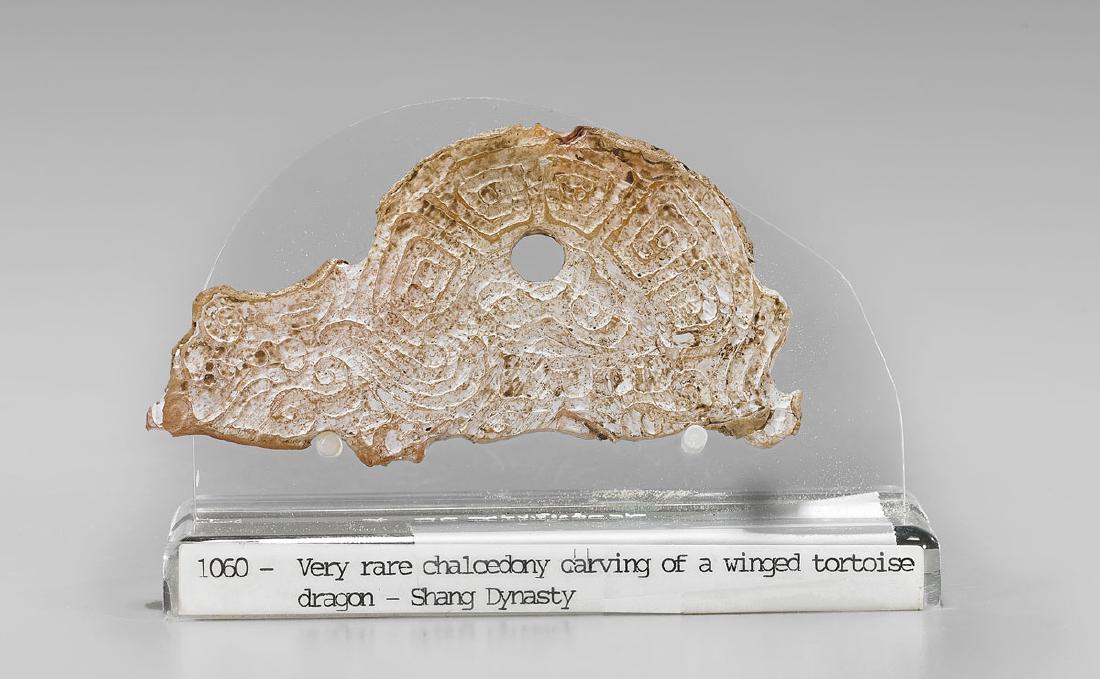 SHANG-STYLE CARVED HARDSTONE PLAQUE: Chinese Shang-style carved hardstone dragon-form plaque; L: 3 1/2"