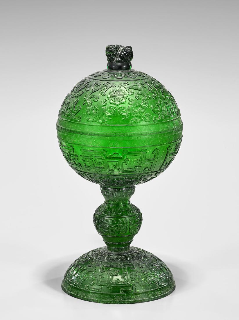 CARVED GREEN GLASS STEM VESSEL: Chinese carved green glass covered sectional stem vessel; the metallic-flecked glass decorated with archaistic patterns and lion-form finial; H: 17"