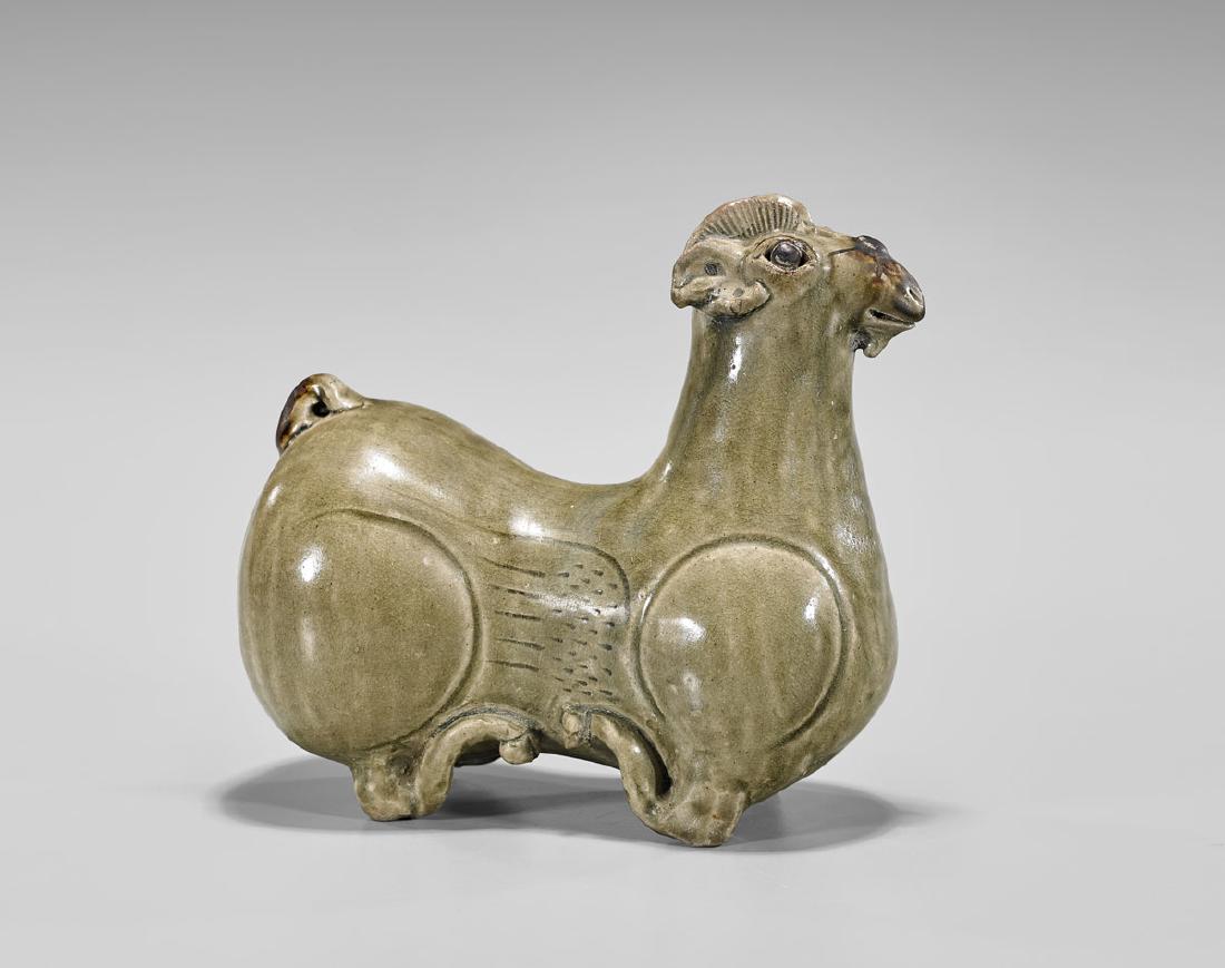 JIN DYNASTY CELADON GLAZED RAM: Chinese Jin Dynasty celadon glazed model of a ram; seated in recumbent pose, with moulded and incised detailing; L: 6 1/2"