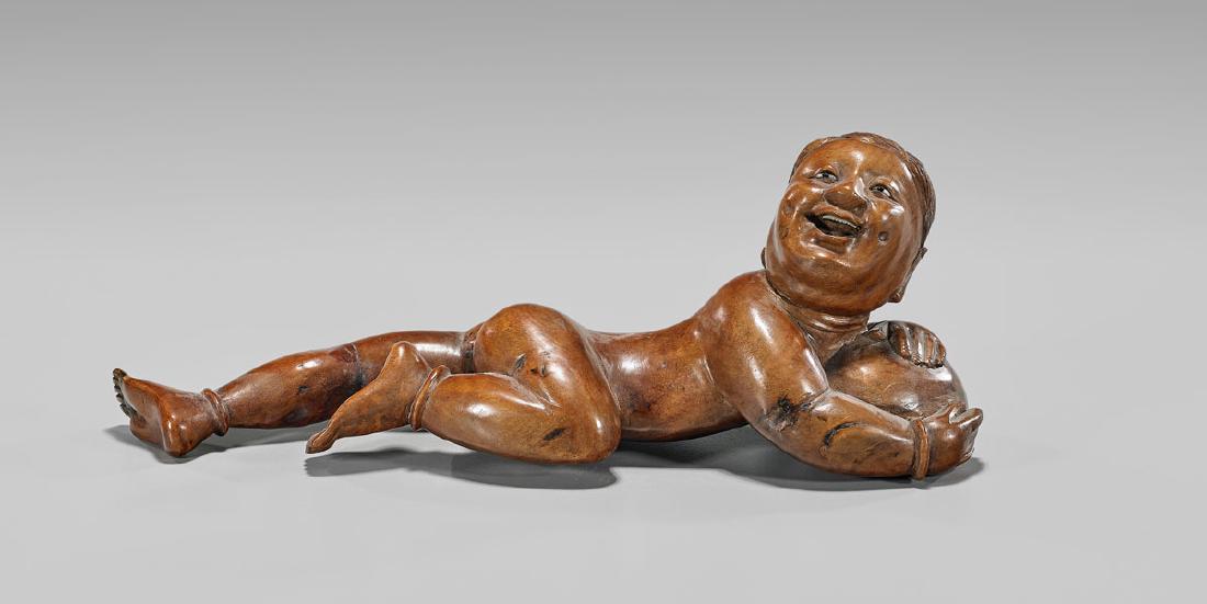 19TH CENTURY WOOD FIGURE OF A BOY: Chinese carved wood figure of a reclining boy; 19th Century; L: 12"
