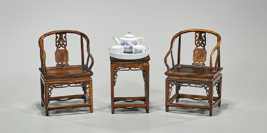 Group of Seven Miniature Chinese Pieces: Group of seven miniature Chinese pieces, including: pair miniature carved wood chairs with side table; together with blue and white porcelain tea set, comprising teapot, two cups, and tray; H: 5 3/4&#