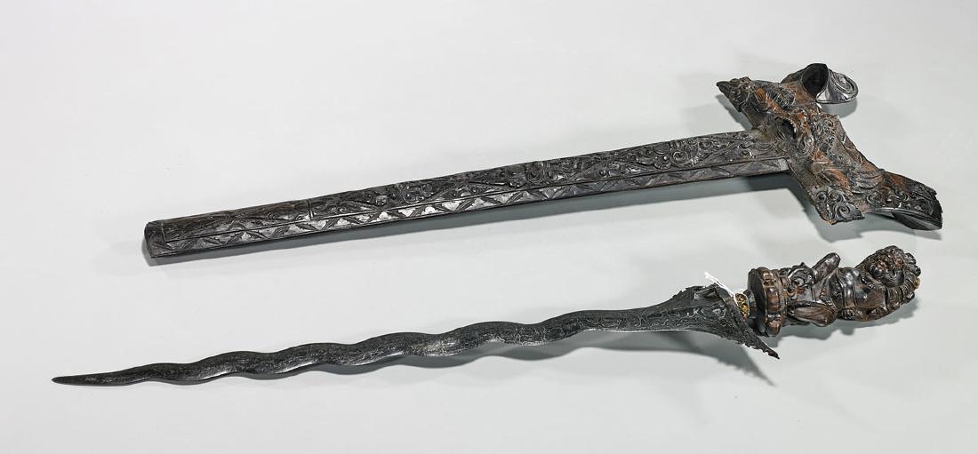 Indonesian Kris Dagger: Indonesian kris dagger; encased in a carved wood sheath and handle; Provenance: Private collection, Beverly Hills; L: 25" (approx.)