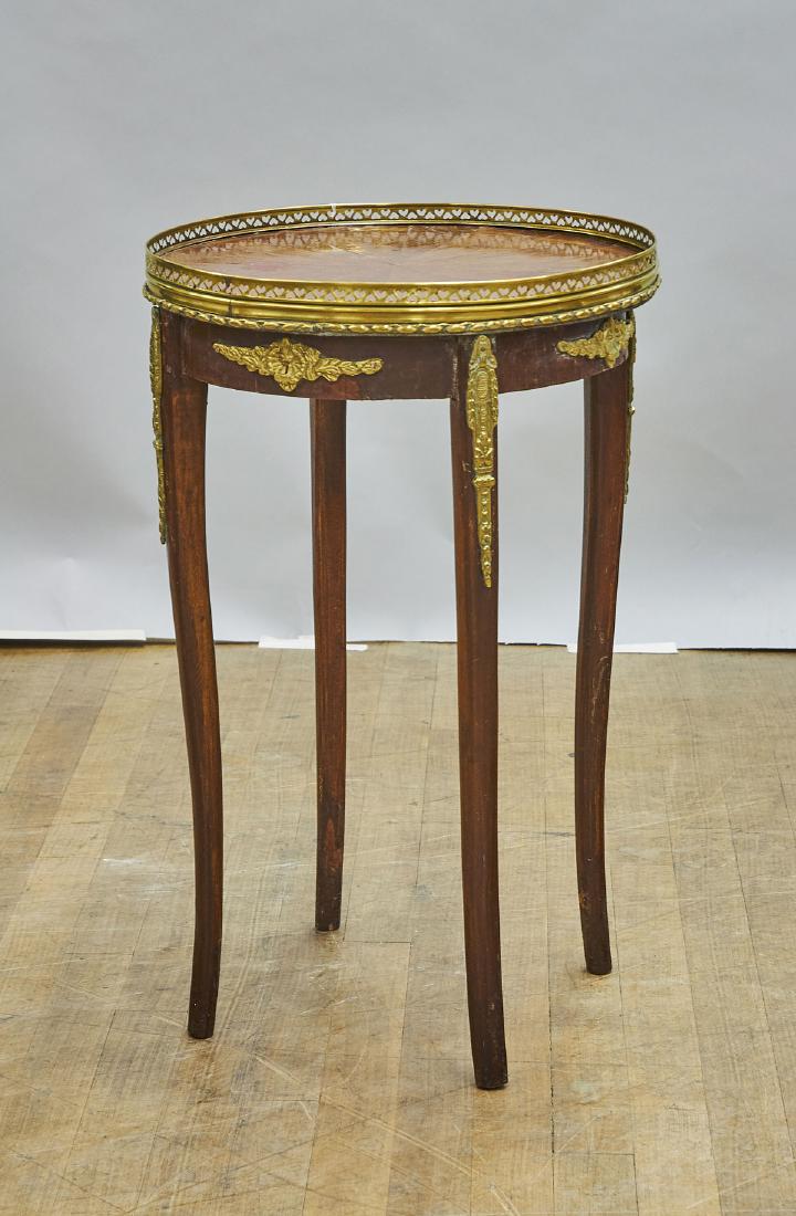 Ormolu-Mounted Wood Side Table: Ormolu-mounted wood side table; the round top; resting atop three cabriole legs; Provenance: Estate of Rafael de Marchena-Huyke; 24" x 15" (approx.)