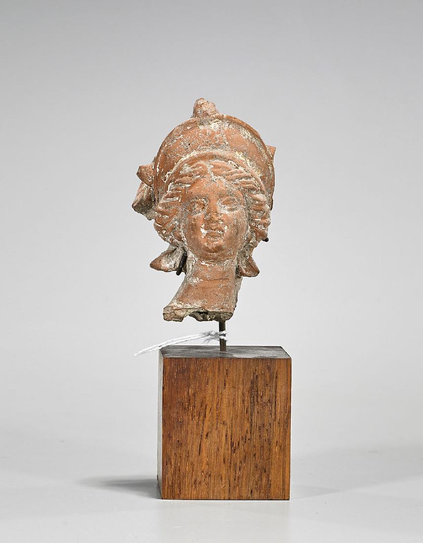 Ancient Greek Earthenware Head of a Goddess: Ancient Greek earthenware head of a goddess; of Athena or Aphrodite; Provenance: Collection of Dr. Robert Ramsey; H: 3 1/4" (approx.); wood and metal stand