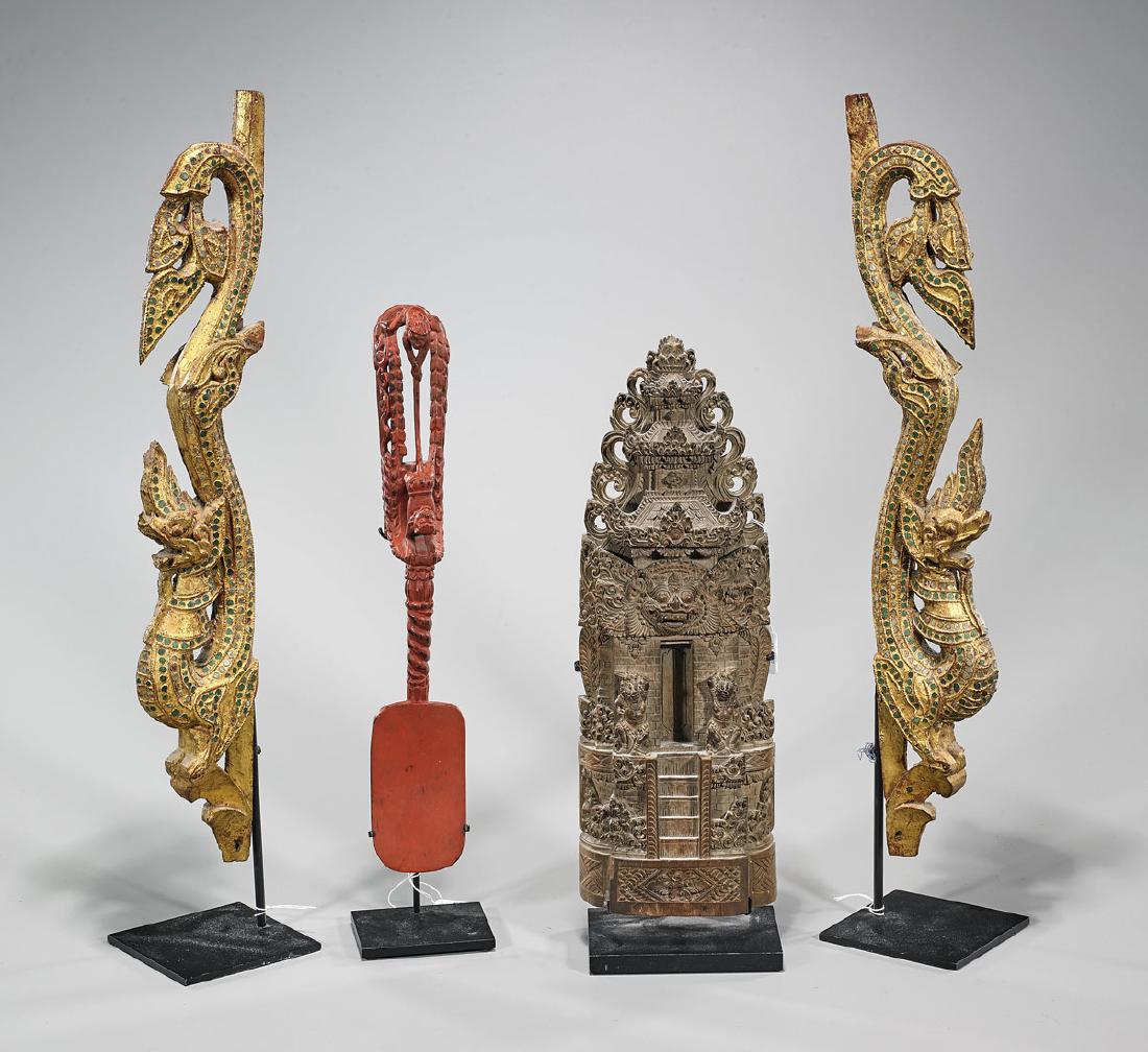 Group of Four Indonesian Wood Carvings: Group of four Indonesian wood carvings: pair, with green 'jewels'; temple; together with implement; H: 19 3/4" (tallest, approx.); each with metal stand