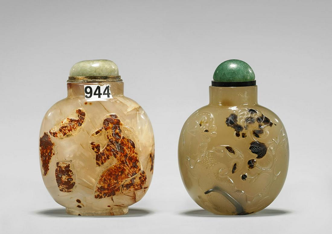 TWO ANTIQUE CARVED AGATE SNUFF BOTTLES: Two antique Chinese translucent agate snuff bottles, each of bulbous form: gray toned with charming and well detailed carving of squirrels amid peonies in light relief, some darker inclusions, with gr