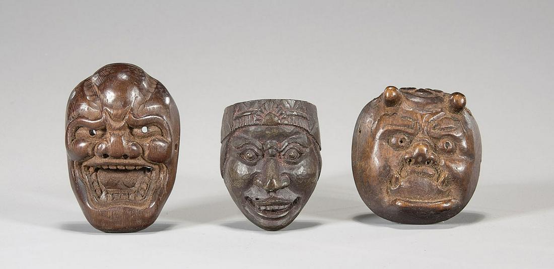 Three Old & Antique Wood Mask Netsuke: Three old and antique Japanese carved wood Noh mask netsuke, of demons: round with stubby horns; one baring teeth in grimace; and one with headdress and sharp nose; Provenance: the Estate of Ted Adame