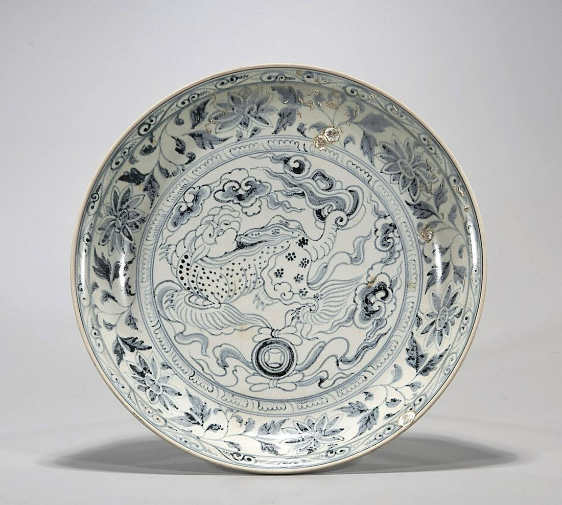 16th Century Vietnamese Blue & White Porcelain Dish: Antique Vietnamese blue and white porcelain shipwreck dish; decorated with a qilin at center with coin and ribbon flanked by clouds, framed by a wide border of lotus blossoms; the underside with a bor