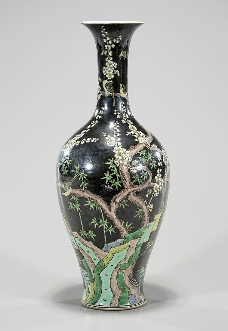 Chinese Enameled Porcelain Vase: Chinese black ground porcelain vase with blossoming branches and bird motif; Kangxi mark but later; 17" x 7" (approx.) Condition: general wear, frits, pits