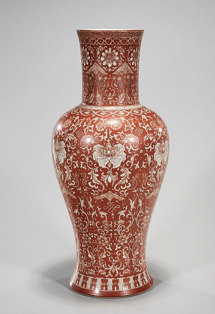 Chinese Enameled Porcelain Vase: Chinese coral red ground porcelain vase with repeating floral design; 18 1/2" x 8 1/2" (approx.) Condition: general wear, frits, pits, minor chips