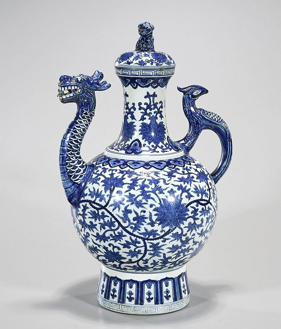Chinese Blue and White Porcelain Covered Vessel: Chinese blue and white porcelain covered vessel; dragon spout and phoenix handle; floral design; mark to base; 17" x 11" x 7 1/2" (approx.) Condition: general wear, frits, pits, minor chips