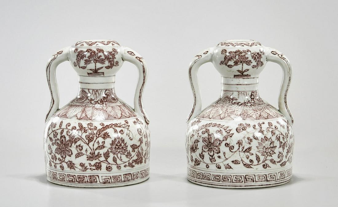 Pair Chinese Red and White Handled Vases: Pair of Chinese red and white porcelain handled garlic mouth vases; scrolling floral design; Xuande mark to each base but later; 8" x 6" (approx.) Condition: wear, frits, pits, minor loss