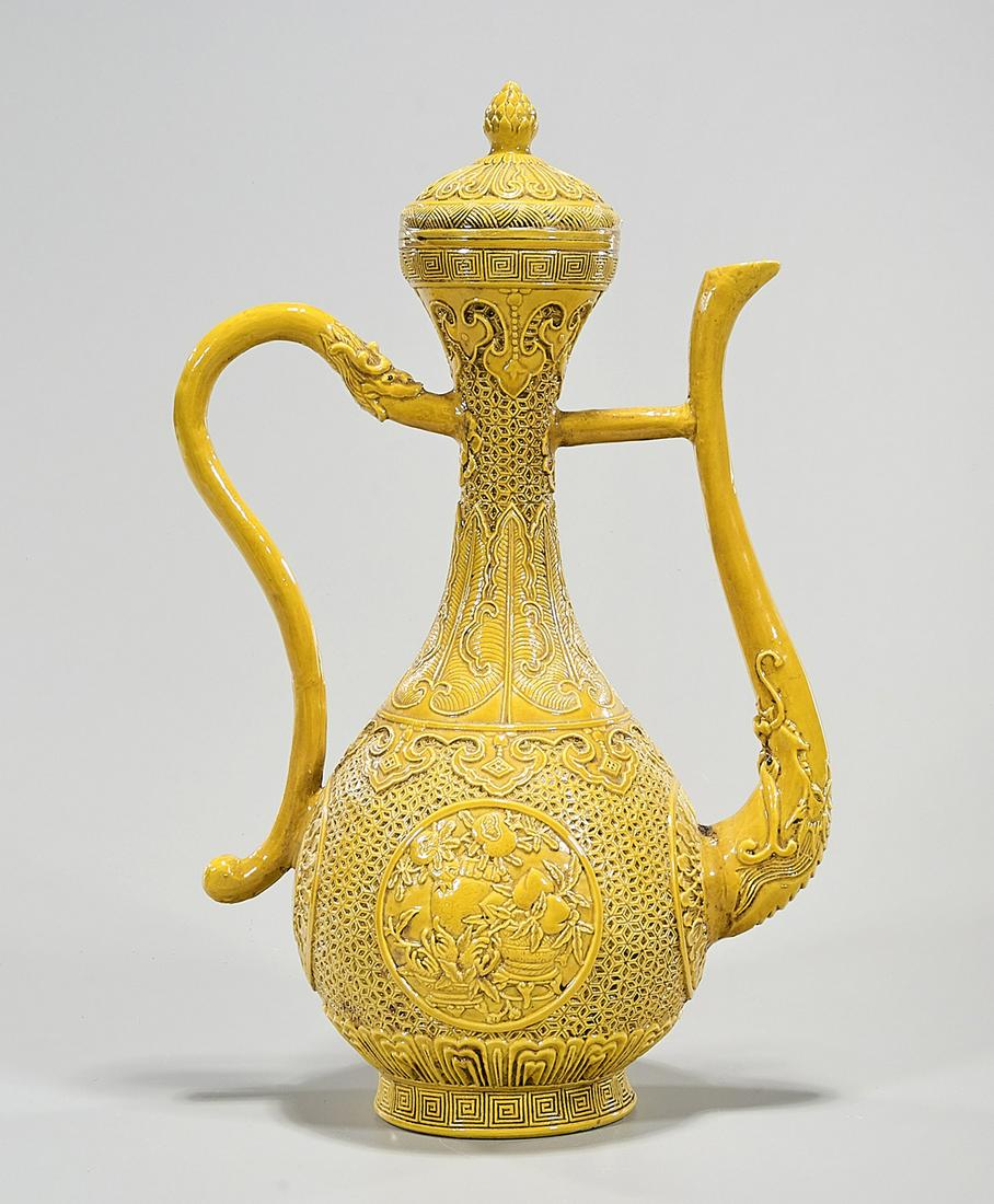 Chinese Glazed Porcelain Covered Vessel: Chinese yellow glazed porcelain handled covered vessel; carved relief, flowers, banana leaf pattern; 15" x 9 1/2" x 6" (approx.) Condition: wear, frits, pits, minor loss