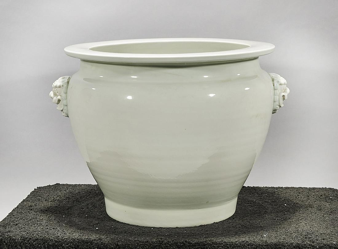 Chinese White Glazed Porcelain Jardiniere: Chinese white glazed porcelain jardiniere; lion head handles; 15 1/2" x 21 1/2" (approx.) Condition: wear, frits, pits, minor loss