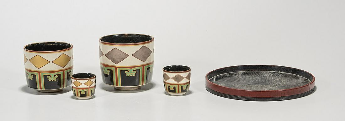 Group of Four Japanese Tea Cups: Four Japanese porcelain tea cups with wood tray; 3 1/2" x 4" (each, approx.); (tray: 7 1/2", approx.) Condition: wear, minor losses