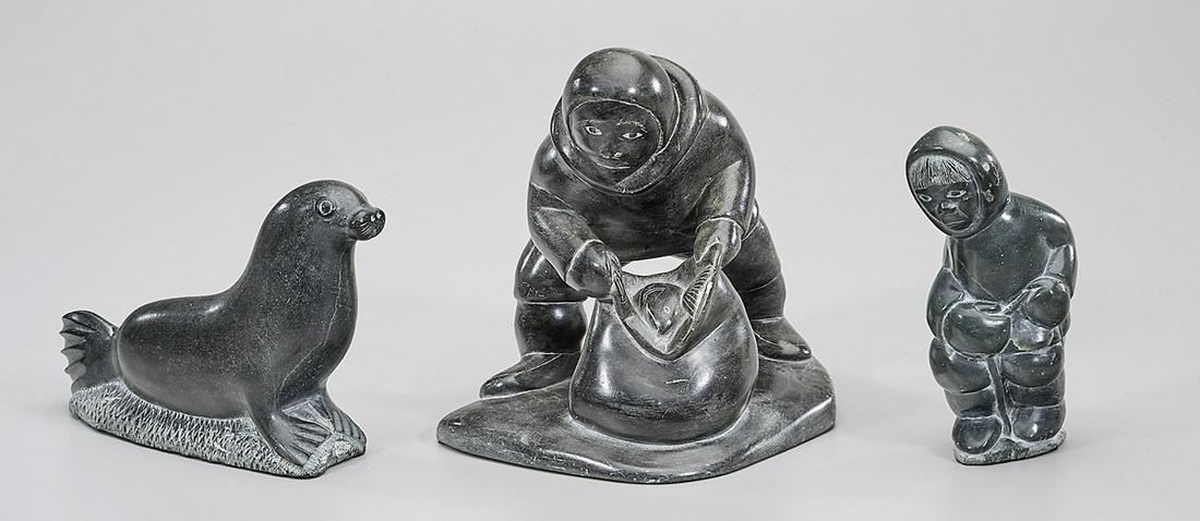 Group of Three Inuit Stone Carvings: Three Inuit stone carvings; including a fisherman by David Kerkok, an eskimo and seal; each with artist label; 7" x 8 1/2" x 6" (tallest, approx.)