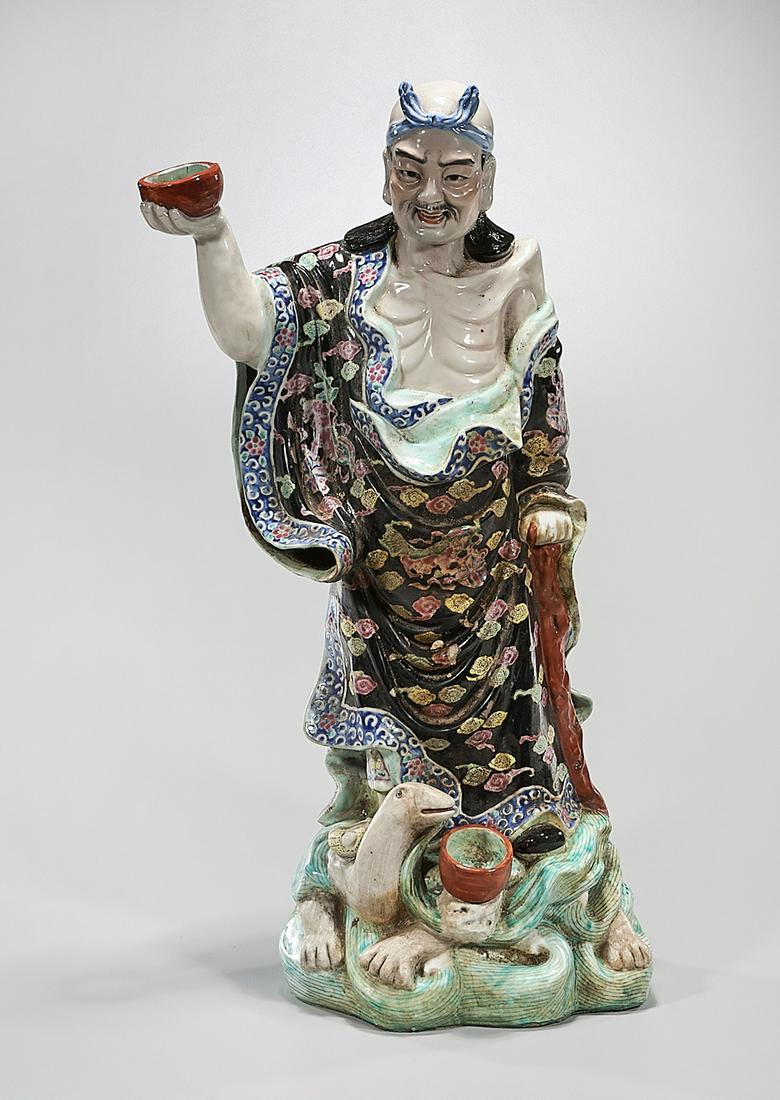 Chinese Enameled Porcelain Figure: Chinese enameled porcelain figure; standing on a turtle; 24 1/2" x 10" x 8" (approx.) Condition: general wear, frits, pits, minor losses