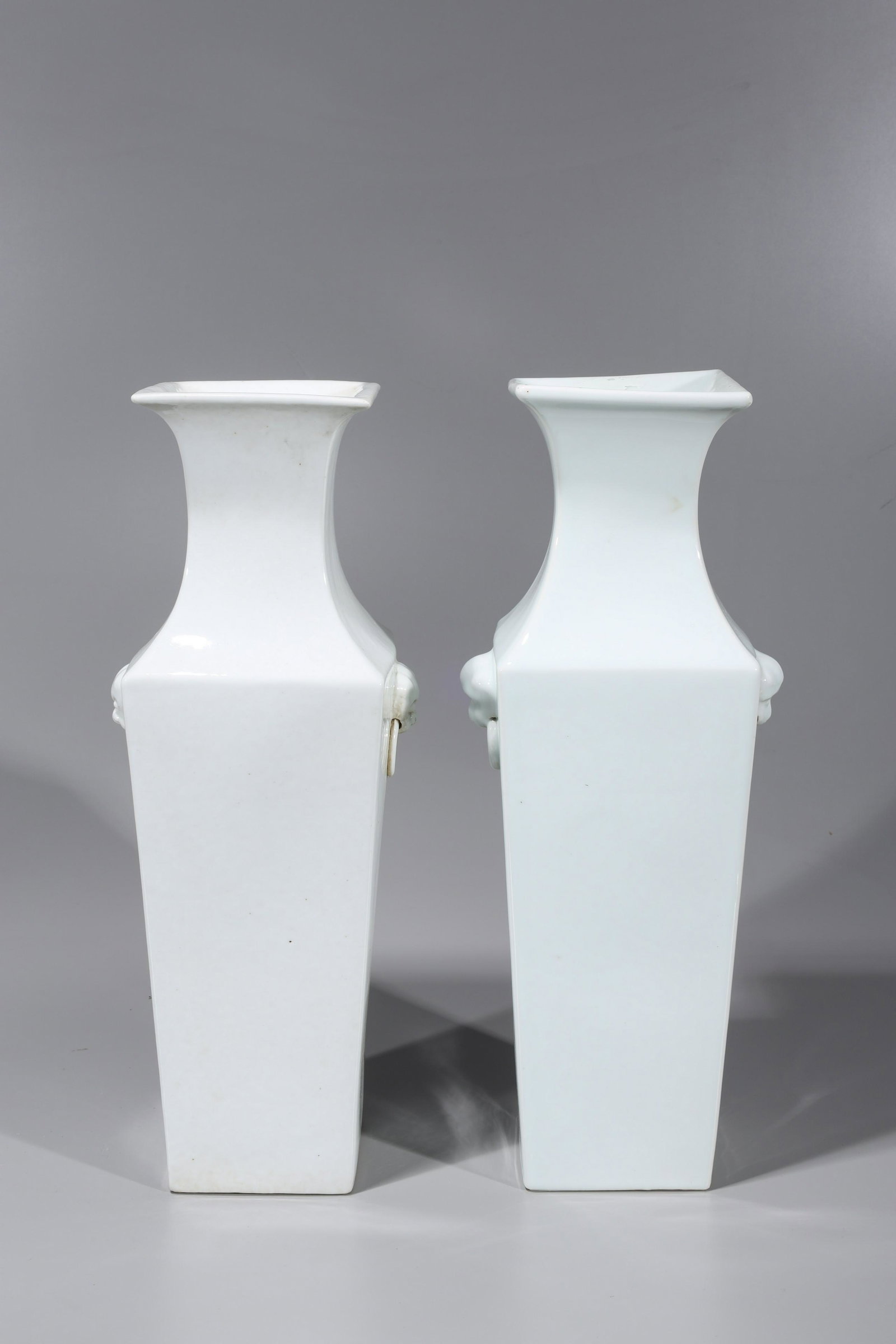 Pair Chinese White Porcelain Vases: Pair of Chinese square form white porcelain vases with mask handles; overall good condition, some surface wear, surface scratches, minor flaws, minor glaze flaws; H 18 1/4" x W 5 3/4" x L 5 3/4" (appr