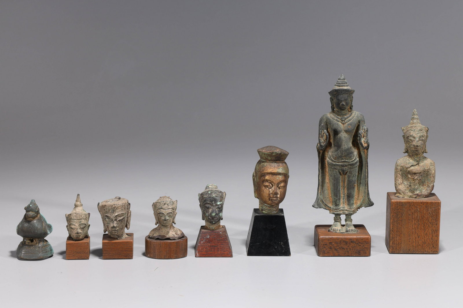 Group of Sino-Tibetan & Burmese Metalworks: Group of Sino-Tibetan figures and heads, all with wood stands, along with one Burmese opium weight; the largest H 7 1/2" x W 2 1/2" x L 2" (approx.) Provenance: Private Beverly Hills, CA collection