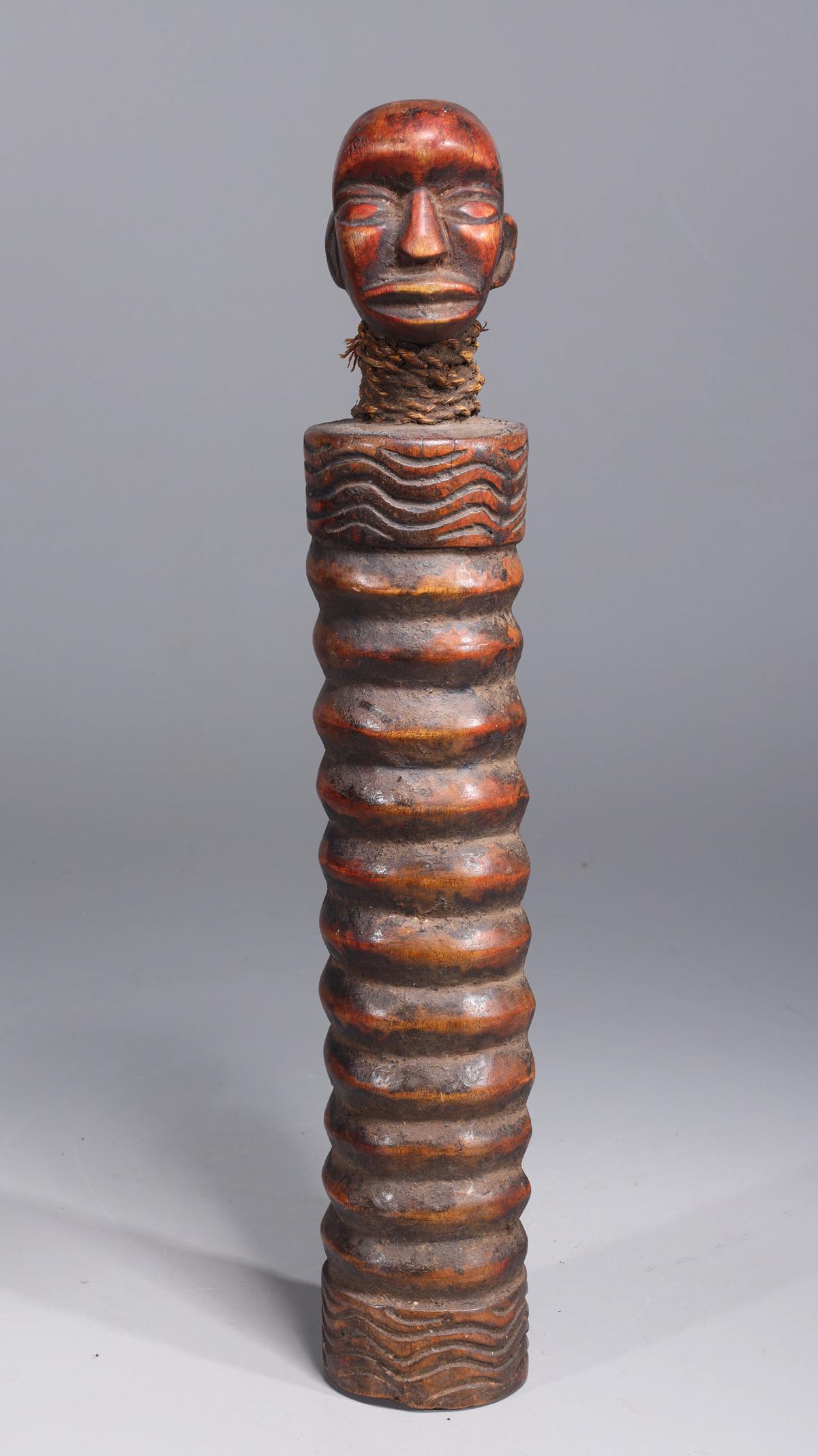 African Yaka Slit Drum: African Yaka slit drum, with rib and wave details to body, expressive face at the top with rope around the neck which would have also been attached to the drumstick which is missing; overall good cond