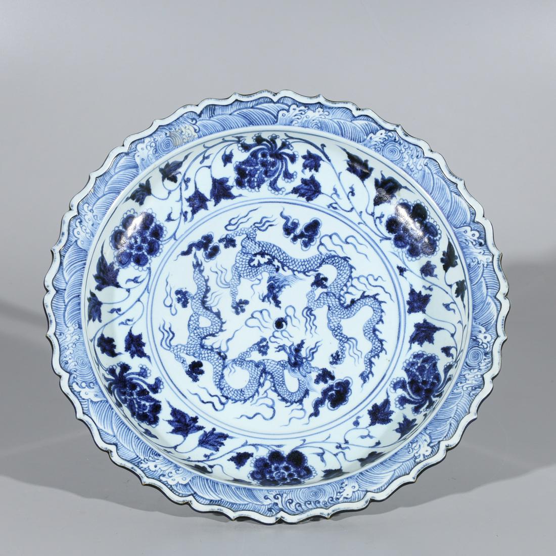 Chinese Blue and White Porcelain Charger: Chinese blue and white procelain charger featuring two dragons in the central design, floral motif and ornate edges; condition: pitting and glaze flaws throughout; W 14 1/2" x H 2 1/2"