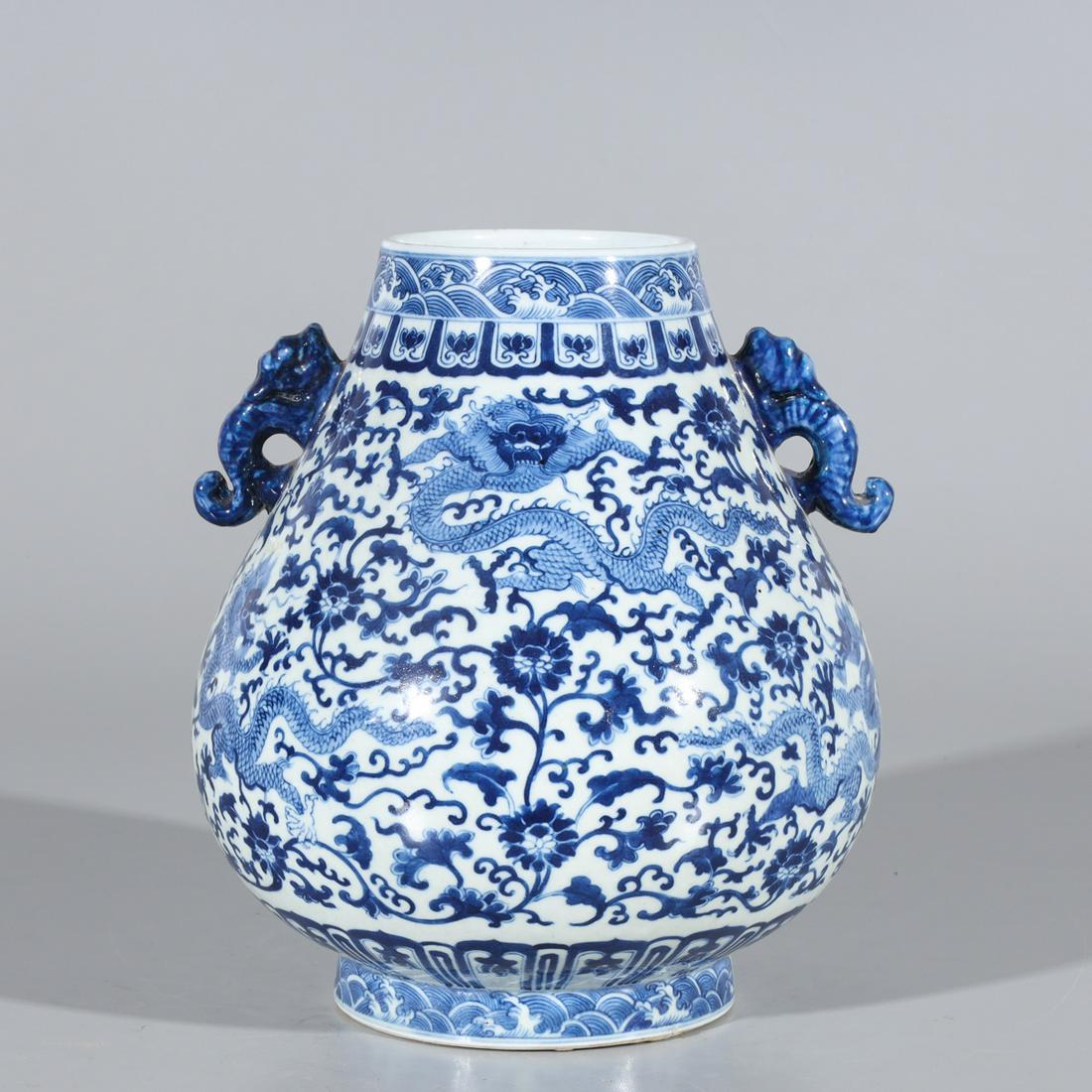 Chinese Blue & White Porcelain Dragon Vase: Chinese blue and white porcelain vase with molded handles, dragons and flowers to body, with six-character Qianlong mark to base; overall good condition, minor wear; H 10 1/4" x D 8 3/4" (approx.)