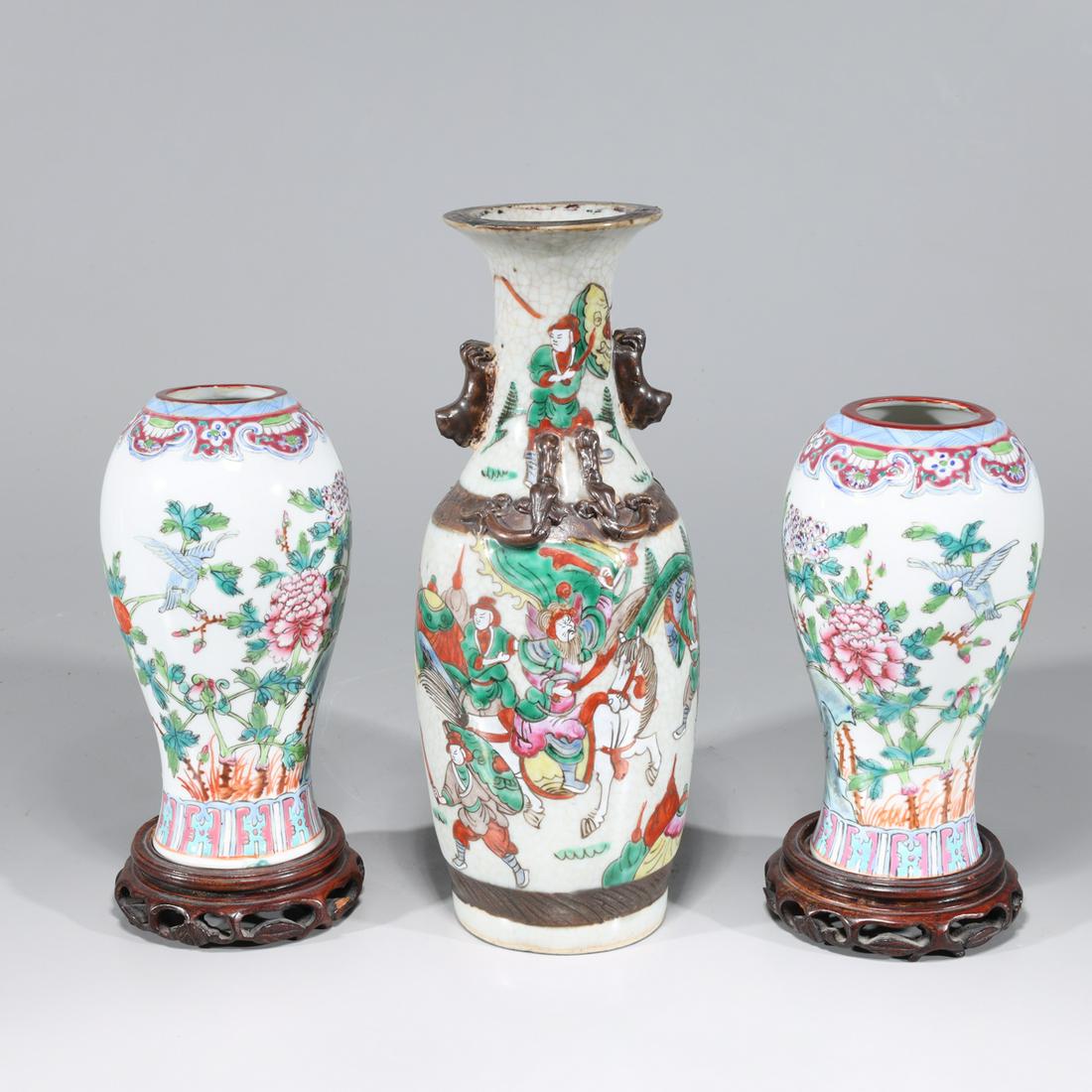 Group of Three Chinese Famille Rose Enameled Porcelain: Group of three Chinese famille rose enameled porcelain vases, two with wood stands and floral figures, one with molded handles and characters to body; overall good condition, minor wear; the largest v