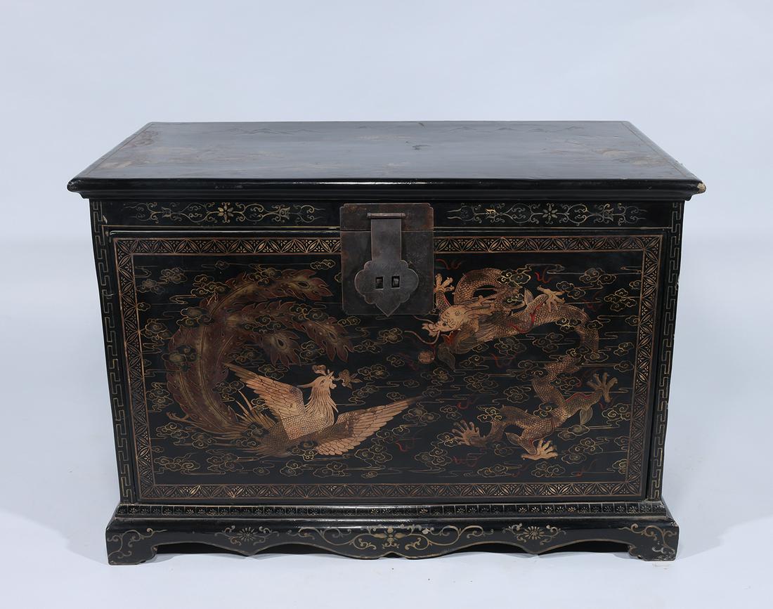 Chinese Lacquered Chest: Chinese lacquered and gilt chest with phoenix and dragon chasing flaming pearl amidst clouds, with floral designs; some wear, some chips to wood and paint, some losses to guilt; H 22" x L 32" x W 17 3