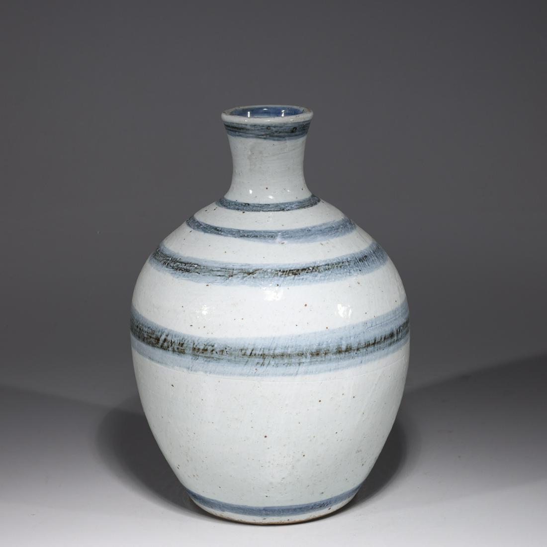 Chinese Blue and White Porcelain Vase: Chinese blue and white porcelain vase with circular blue line design; pitting throughout; H 12" x W 7"