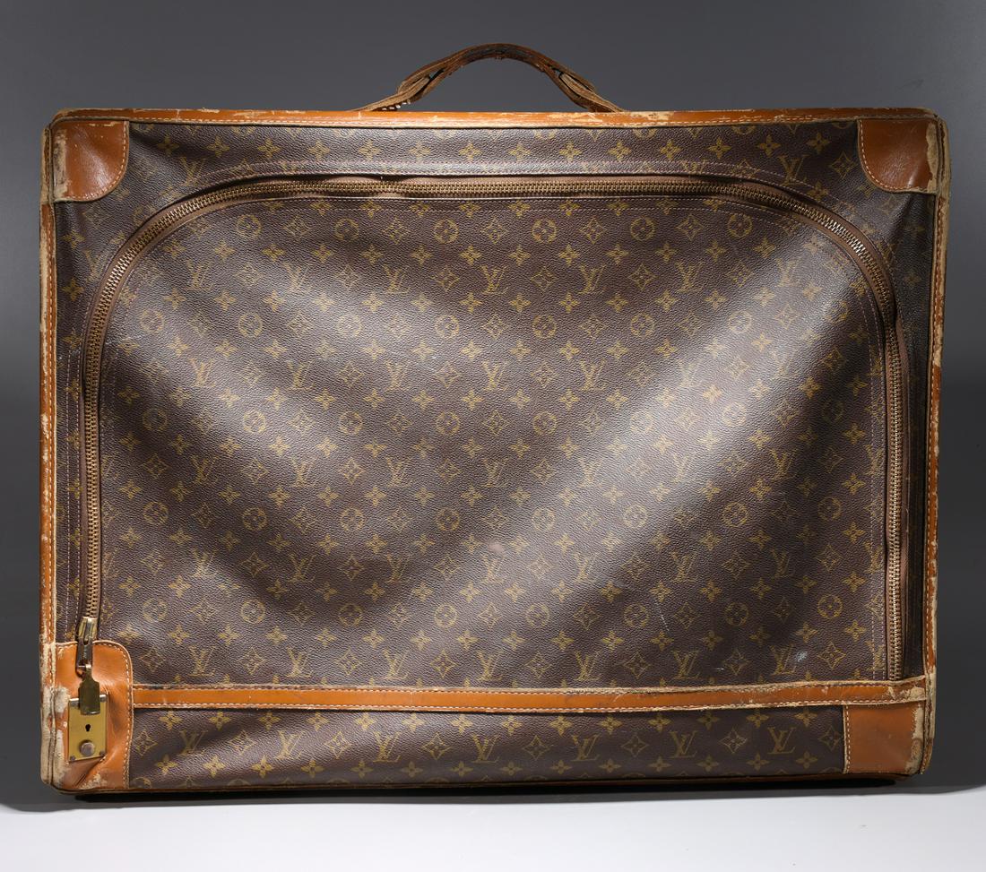 Louis Vuitton Suitcase: Louis Vuitton suitcase with straps, original card on inside; multiple scuffs, scratches and losses around edges and corners of suitcase, as is condition; H 23" x L 28" x W 7"
