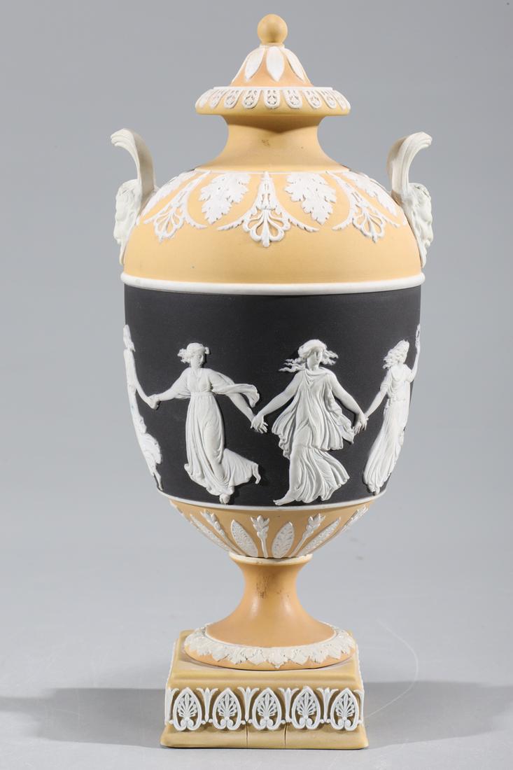 Wedgwood Tri-Color Jasperware Covered Urn: Rare Wedgwood tri-color black, white, and ochre covered urn with dancing figures and foliate designs to body and cover, with molded Pan mask handles to shoulder, base stamped Wedgwood inscribed 275; O