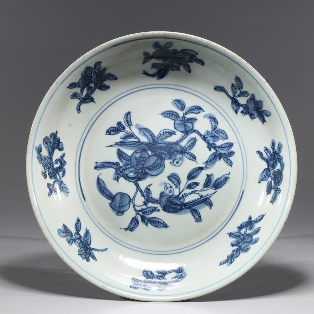 Chinese Blue & White Ming Style Porcelain Dish: Chinese blue and white Ming style porcelain dish with bird and fruit designs to surface, concentric circles to exterior; overall good condition, minor wear to glaze; H 2 1/8" x D 10" (approx.) Provena