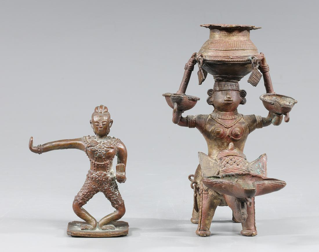 Two Antique Indian Bronzes: Two antique 19th century or earlier bronze figures including small standing figure with arm outstretched with elaborate clothing and body jewelry together with oil lamp in the form of a figure riding