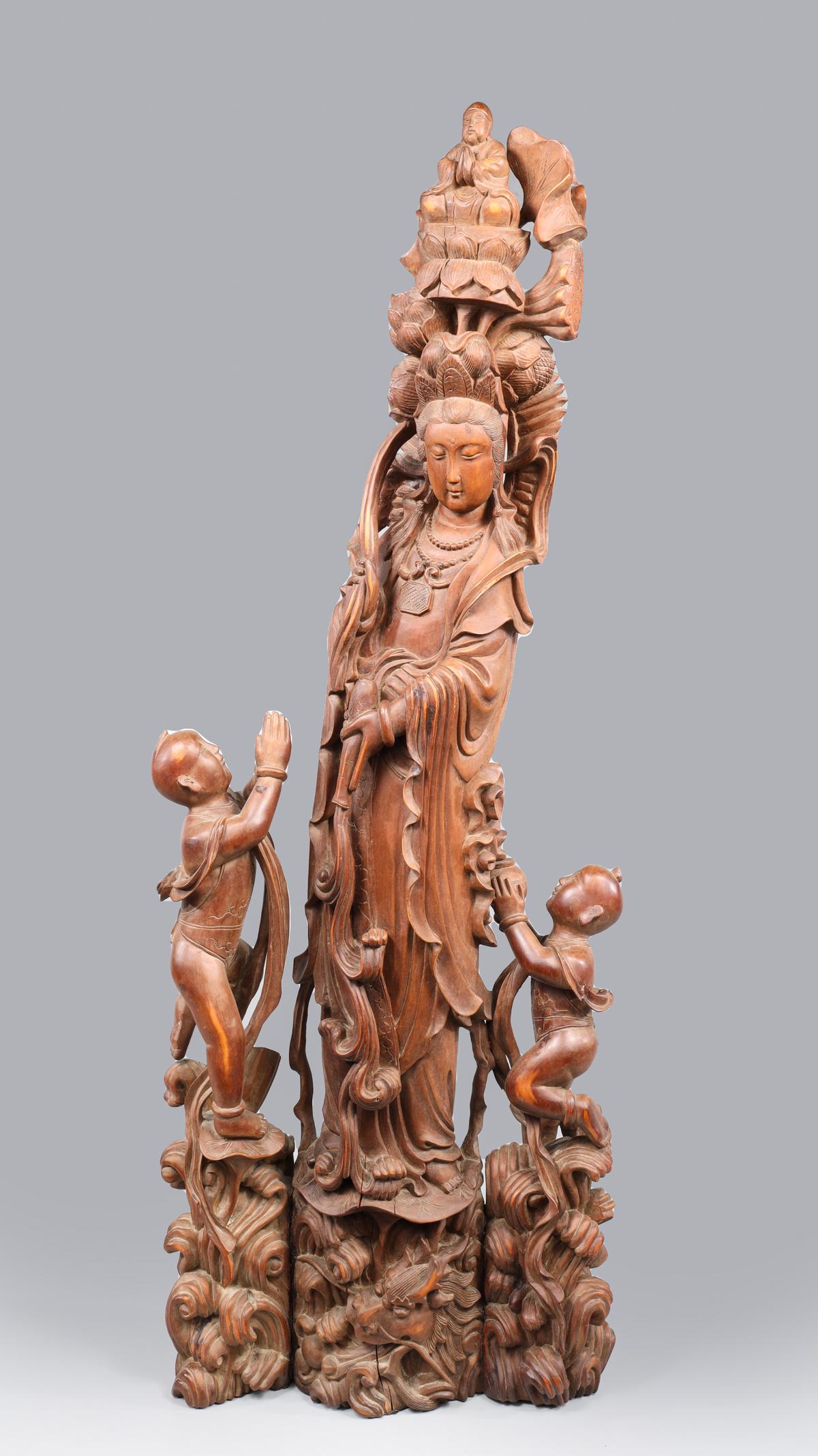 Chinese Carved Guanyin Statue: Chinese carved Guanyin statue above a dragon in turbulent sea flanked by two figures and crowned by Buddha on lotus; overall good condition, some age wear, some surface wear; L 12" W 5" H 32" (Approx.