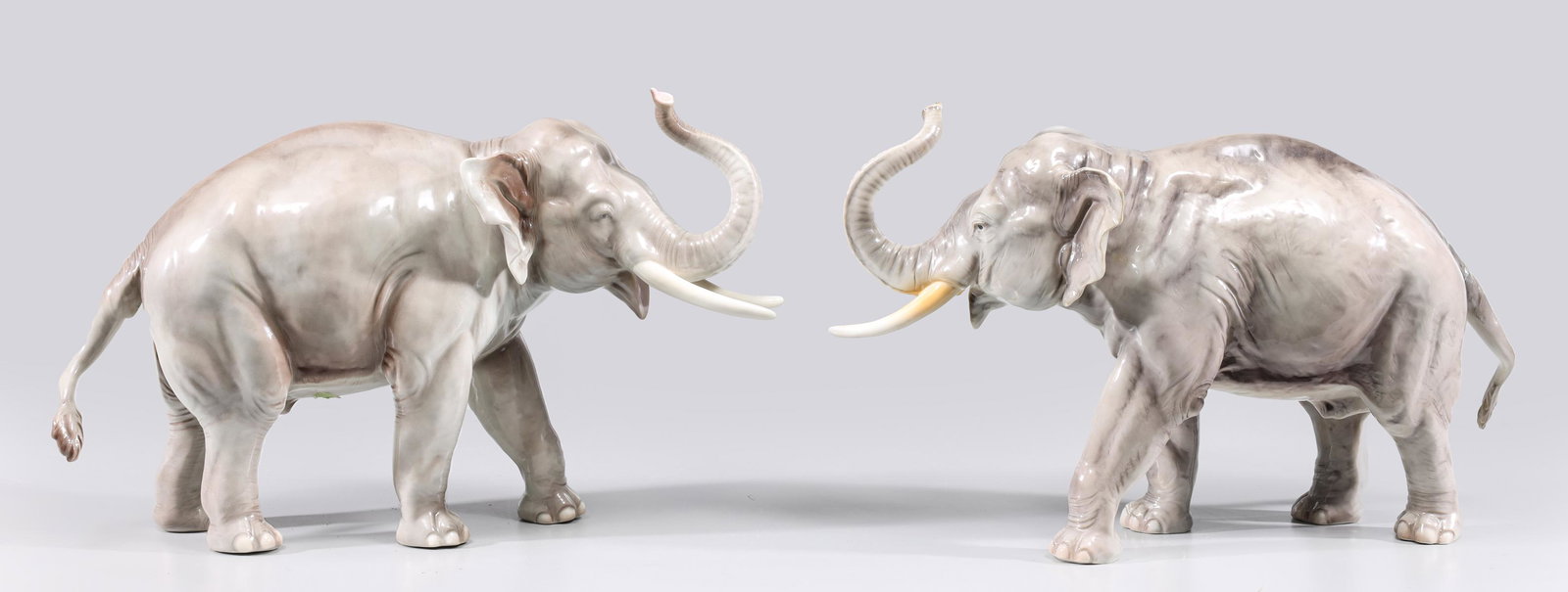 Pair of vintage Nymphenburg Grey Elephants: Pair of vintage Nymphenburg grey porcelain elephants, c. 1930-1950's; broken (detached) tusk, minor chip on trunk, overall good condition, some age wear, surface soiling; L 16" W 5 1/2" H 10 1/2" (App