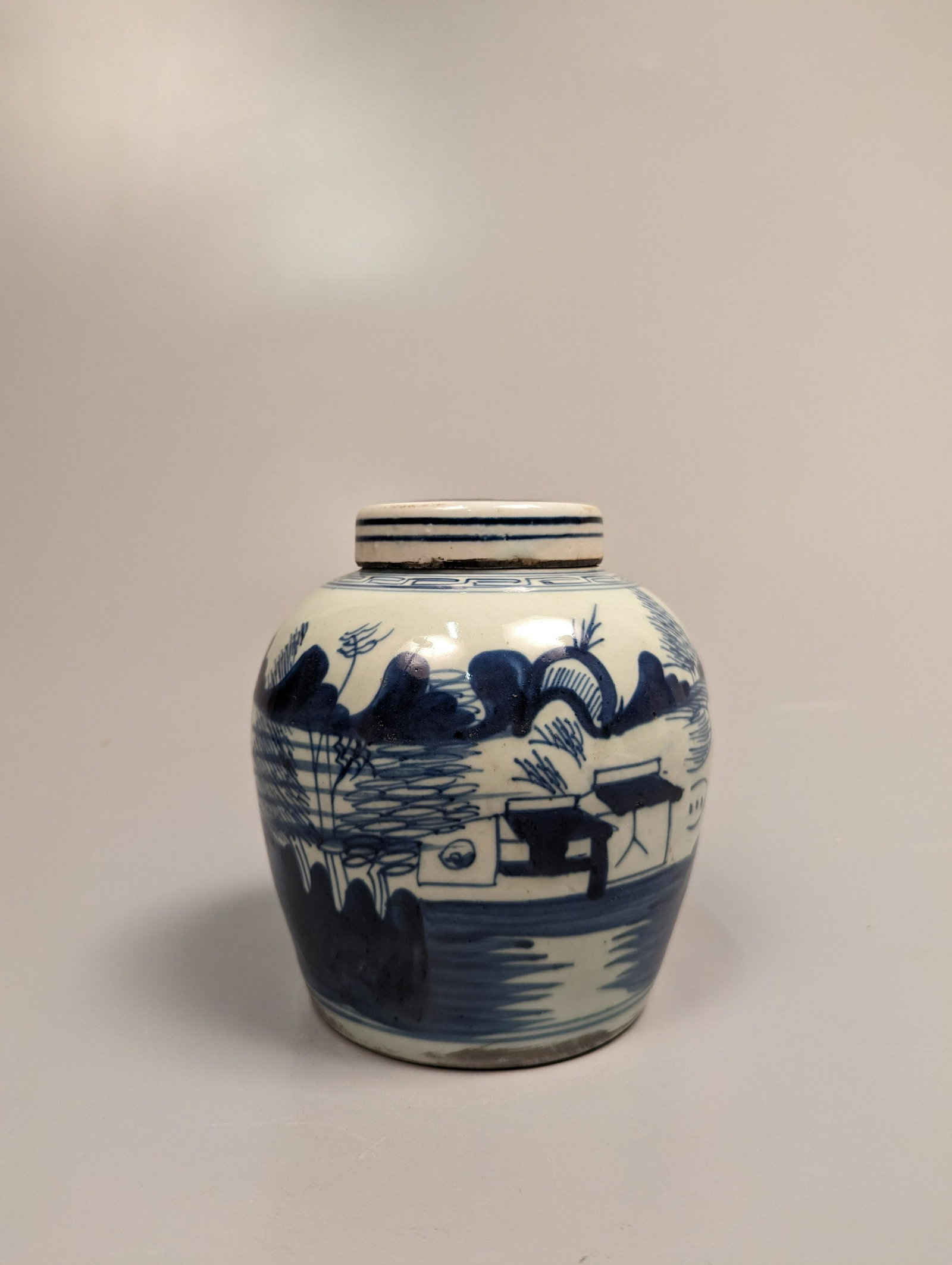 Small Ming-Style Blue and White Covered Jar: Small Chinese Ming-style, blue and white porcelain jar with flat top cover; with landscape design and a fisherman, a keyfret band to shoulder; usual wear, scratches, some frits; H: 5 1/2"