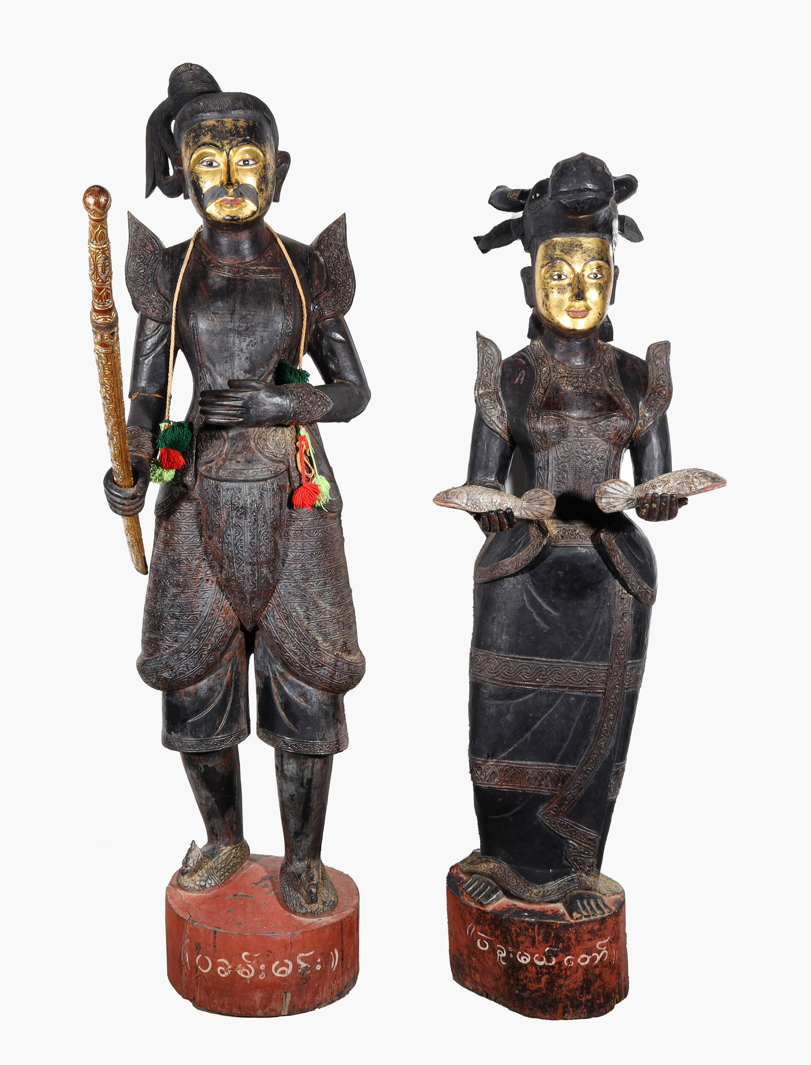 Large & Elaborate Thai Life-size Male and Female Carved Wood Figures: Pair of large Southeast Asian, possibly Thai or Indonesian, life-size lacquered male and female carved wood figures each with elaborately carved robes, gilt faces and inlayed eyes; the female holding 