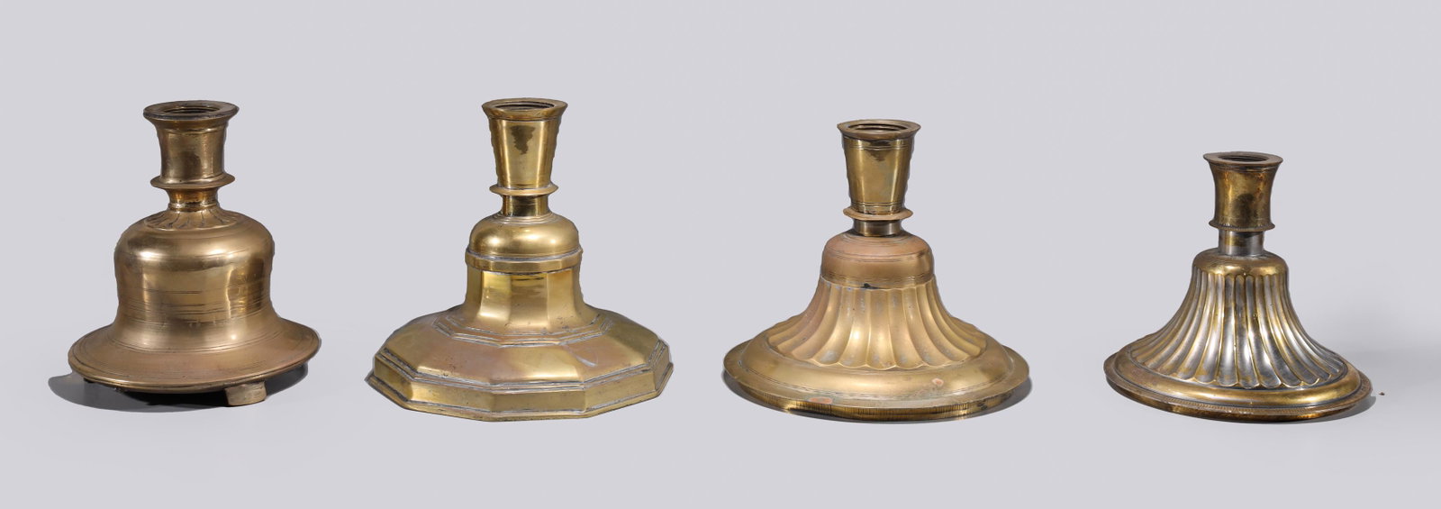 Four Antique Indian Large Gilt Metal Candlesticks: Four various antique Indian large gilt metal candlesticks, 19th century or earlier; as-is condition; the largest H 8 1/2" x D 8 3/4" (approx.) Provenance: Collected between 1945-1960 by Carl O. Winber