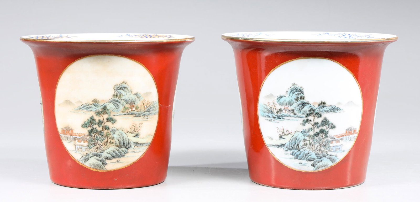 Pair of Chinese enameled Porcelain Flower Pots: Pair of red ground Chinese enameled porcelain flower pots with painted landscape scenes in reserves; each base with mark and two holes; overall good condition with minor wear