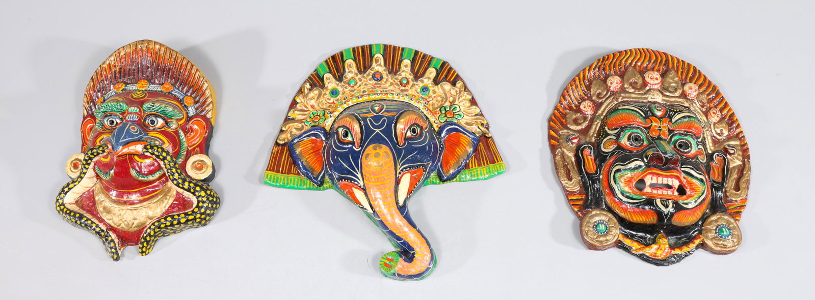 Group of Three Nepalese Hindu Papier-Mache Masks: Group of thee Nepalese Hindu papier-mache masks, depicting: Ganesh, Garuda, and Mahakala; overall good condition, crack and loss on verso of Garuda, light age wear, surface wear; largest L 13" W 3" H 