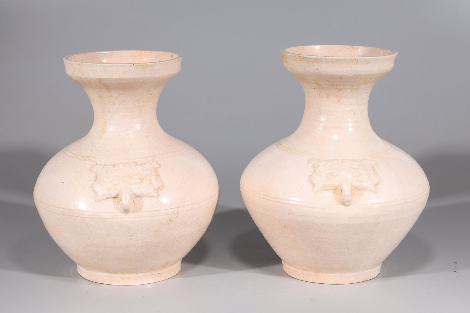 Pair of Early Style Chinese Ceramic Vases: Pair of early style Chinese ceramic vases with molded mask handles and incised concentric rings to body; overall good condition, some soiling to rim and neck; H 12 3/4" x D 10 1/4" (approx.)