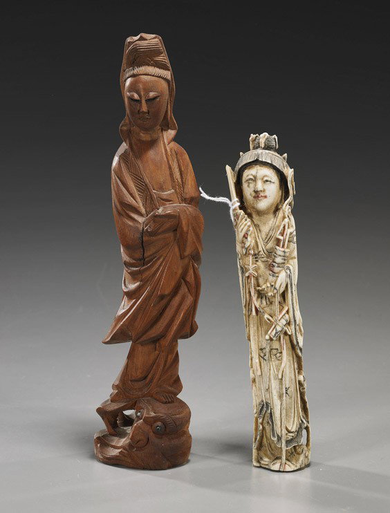 Two Carved Guanyin Figures: Two Carved Guanyin Figures Two Chinese carved Guanyin figures: wood standing in long robes and veil atop a fish (crack); together with an antique polychromed bone, standing and holding a sword in one 