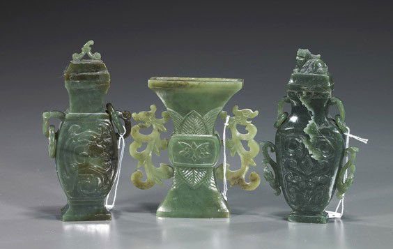 Three Chinese Carved Jade Vases: Three Chinese Carved Jade VasesThree pieces Chinese carved spinach jades: gu-form vase with openwork foliate handles; together with 2 darker archaic bronze form vases, each with 2 loose rings and low