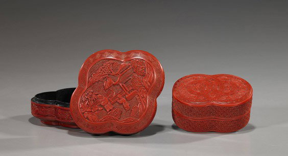 Two Chinese Cinnabar Lacquer Boxes: Two Chinese Cinnabar Lacquer BoxesTwo Chinese carved red cinnabar lacquer boxes: one of double circular form; the other quatrefoil form; each with figural landscape scenes to the cover; L: 6" (larger)