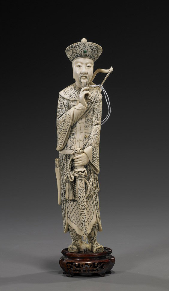 Chinese Carved Ivory Standing Emperor: Chinese Carved Ivory Standing Emperor Chinese carved ivory figure of an Emperor; standing in long dragon robes with armour; caressing his beard with one hand and holding a sword in the other, a bow on