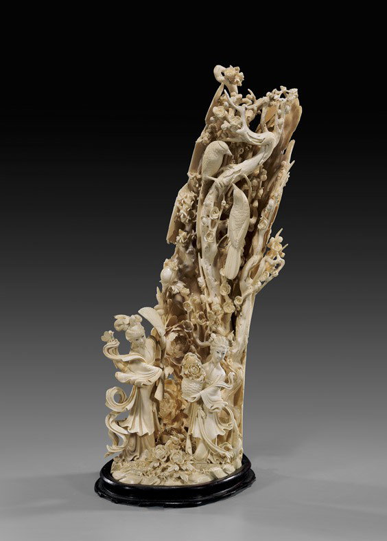 CARVED CHINESE IVORY FIGURAL GROUP: CARVED CHINESE IVORY FIGURAL GROUP Tall and very elaborately carved, Chinese ivory group: of a celestial beauty and her maid dancing in a field of flowers; in front of large bamboo form wall with full
