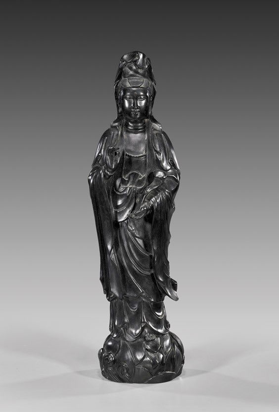 CHINESE CARVED ZITAN WOOD GUANYIN: CHINESE CARVED ZITAN WOOD GUANYINTall Chinese carved Zitan wood figure of Guanyin: holding ruyi scepter, the other hand in mudra; in typical draped robes and standing on a bulbous lotus and wave motif