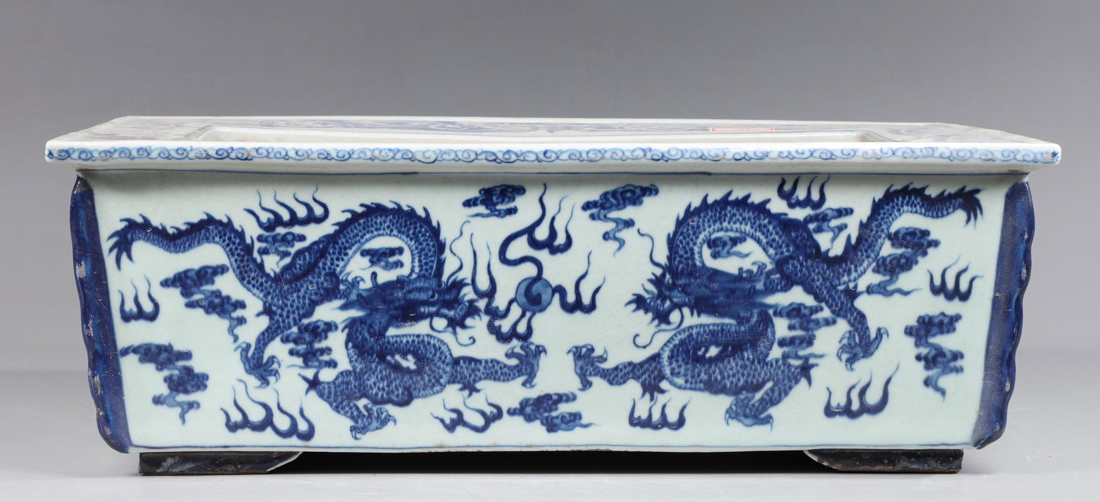 Chinese Blue and White Porcelain Jardiniere: Chinese blue and white porcelain jardiniÃ¨re depicting flying dragons; overall good condition- General marks and age wear, scratches, rubbing, flaws, and losses. Possible restorations; L 18 1/4" W 1